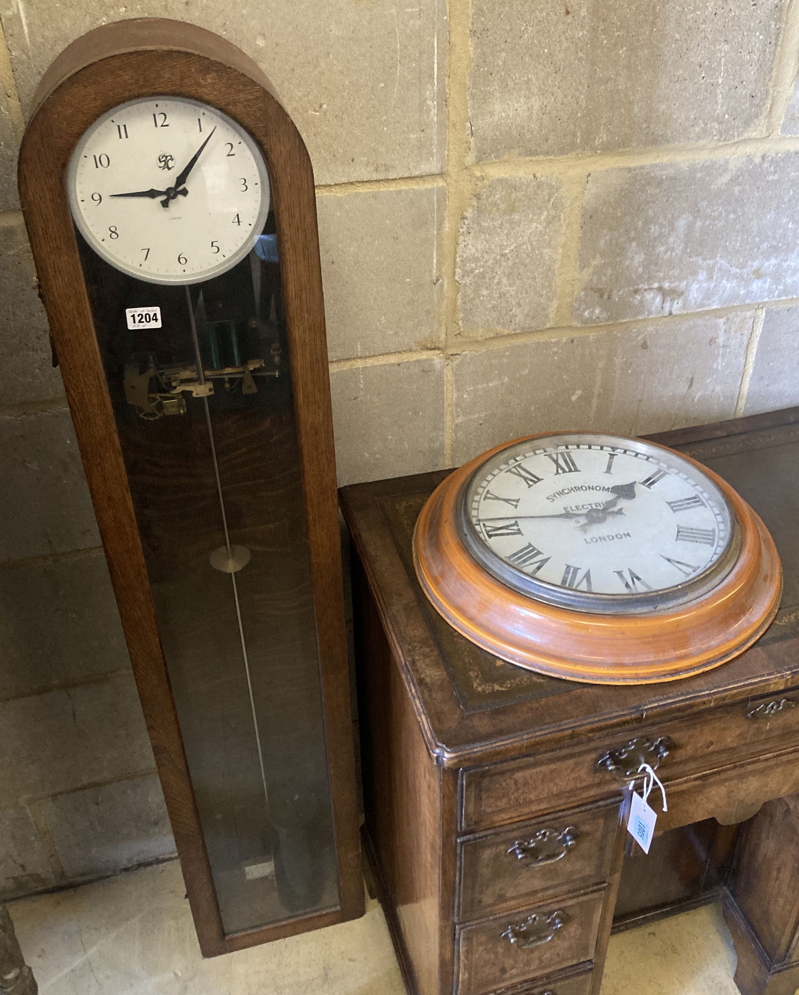 A Smiths English clock systems electric master clock in an arched oak case, with associated pendulum bob, marked ARN Serial No. 30505,